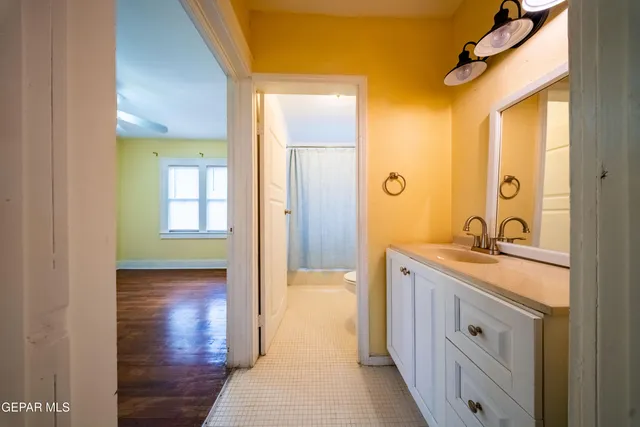 a spacious bathroom with a granite countertop sink a mirror and a shower
