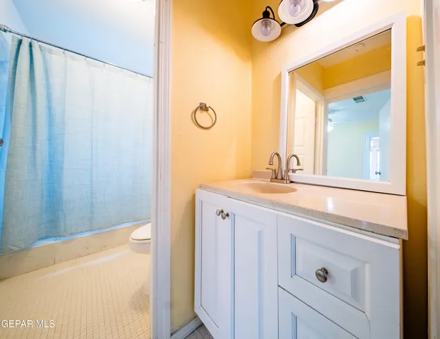 a bathroom with a granite countertop sink and a mirror