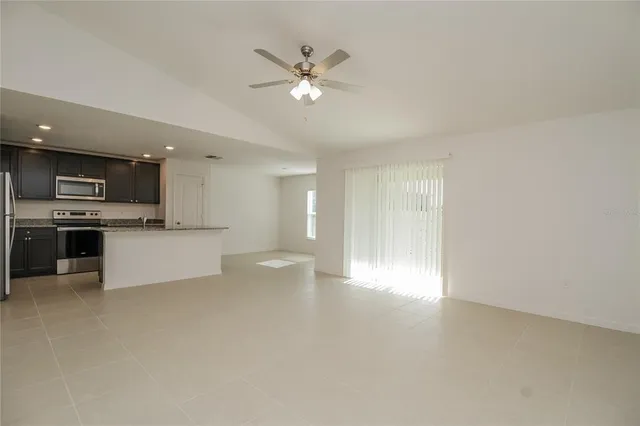 a view of an empty room with a kitchen