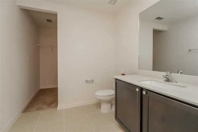 a bathroom with a granite countertop sink a toilet and a mirror