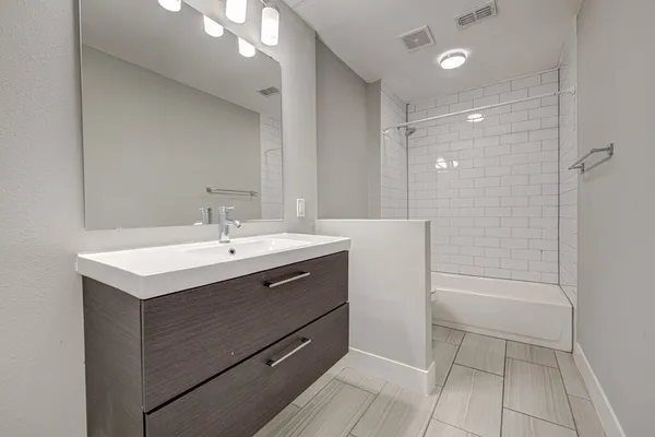 a bathroom with a sink shower and a mirror