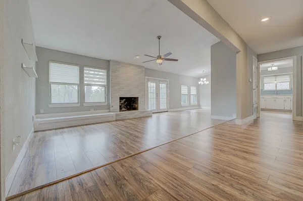 an empty room with wooden floor and windows
