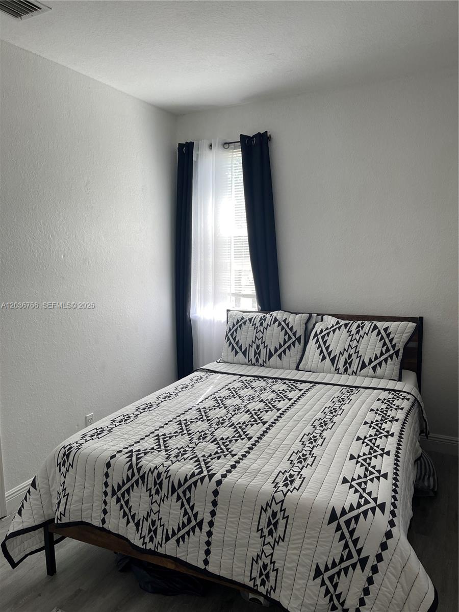 2432 Southwest 99th Way Miramar, FL 33025 - Photo 7 of 17 a bedroom with a bed and a window