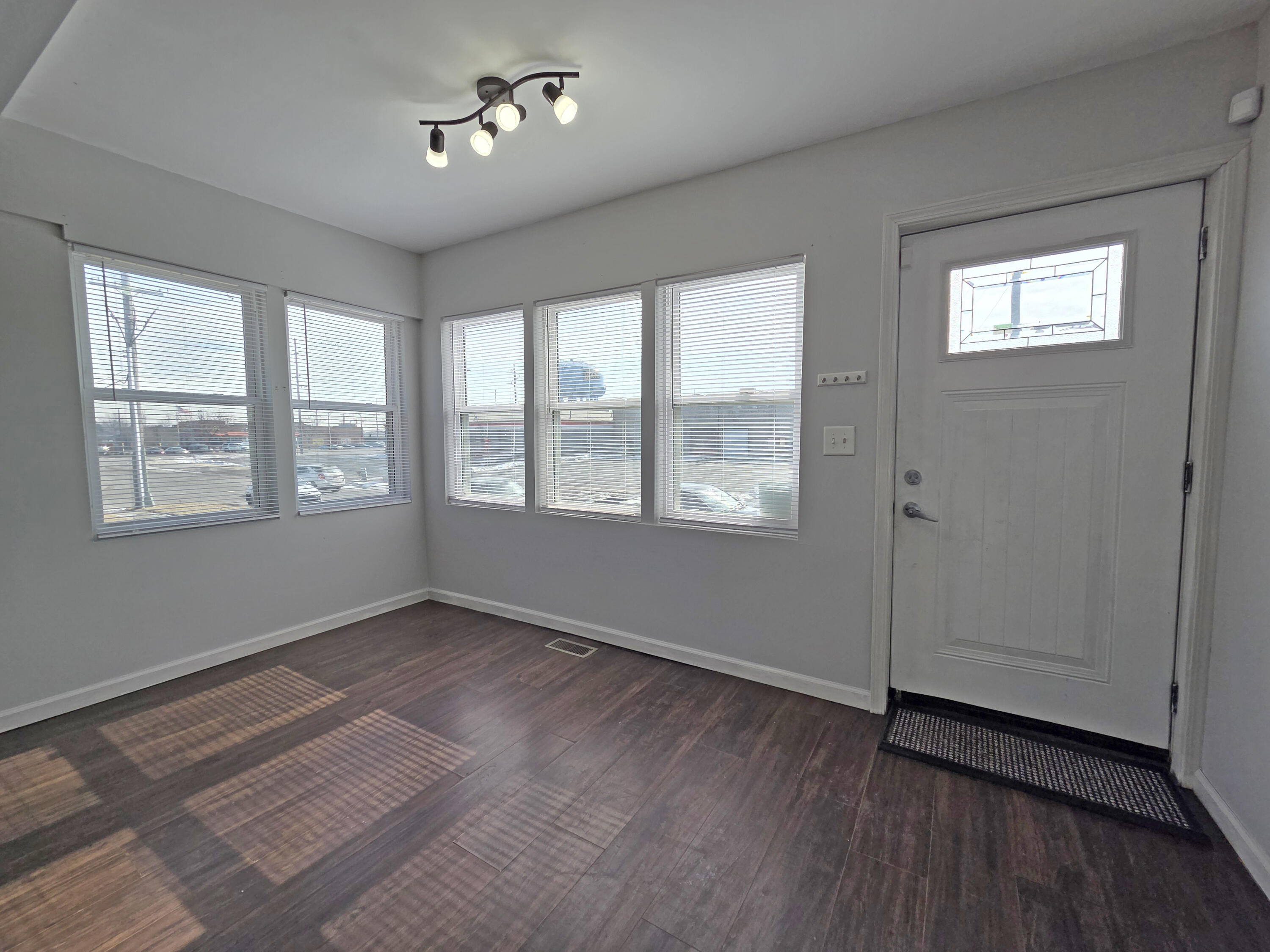 1127 164th Place Hammond, IN 46320 - Photo 9 of 34 a view of an empty room with a window and wooden floor