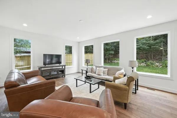 a living room with furniture a flat screen tv and a large window