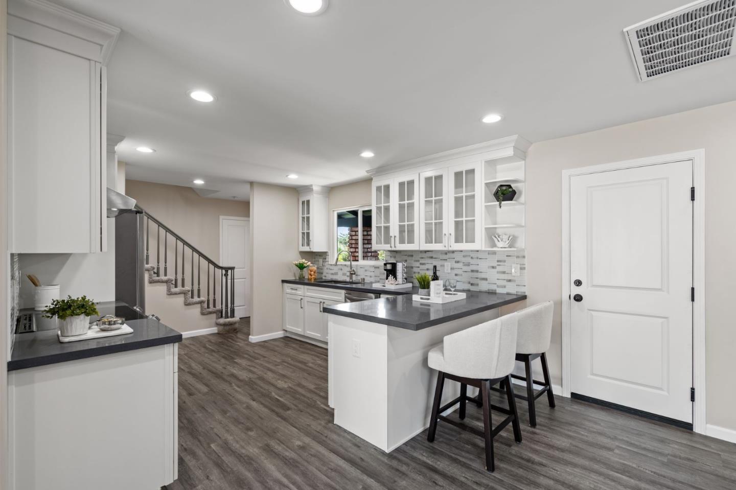 2178 Corktree Lane San Jose, CA 95132 - Photo 7 of 41 a kitchen with stainless steel appliances kitchen island granite countertop a table chairs stove and cabinets