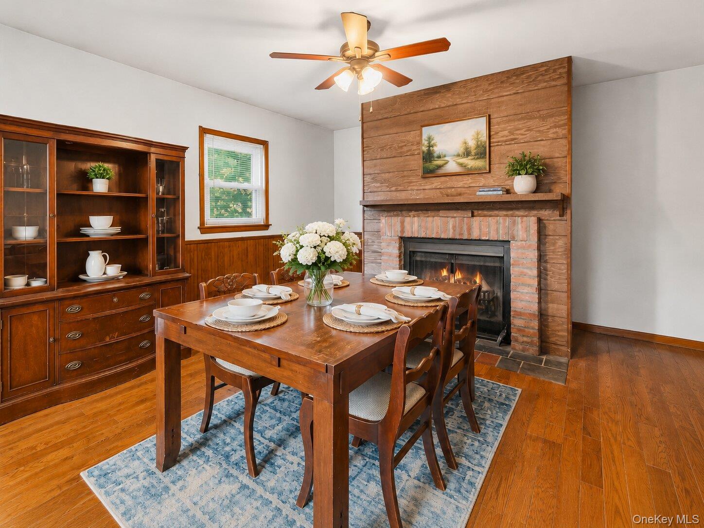 49 Chase Road Wallkill, NY 12589 - Photo 9 of 32 Virtually Staged Dining Area: Warm and inviting formal dining room featuring hardwood floors, a brick fireplace, wood accent details, and plenty of room for gatherings.