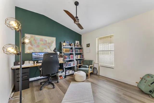 a view of a workspace with furniture and a window