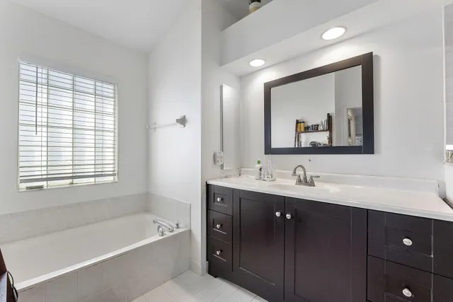 a bathroom with a tub a sink and mirror