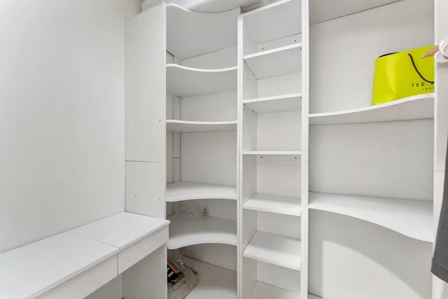 a view of walk in closet with empty racks