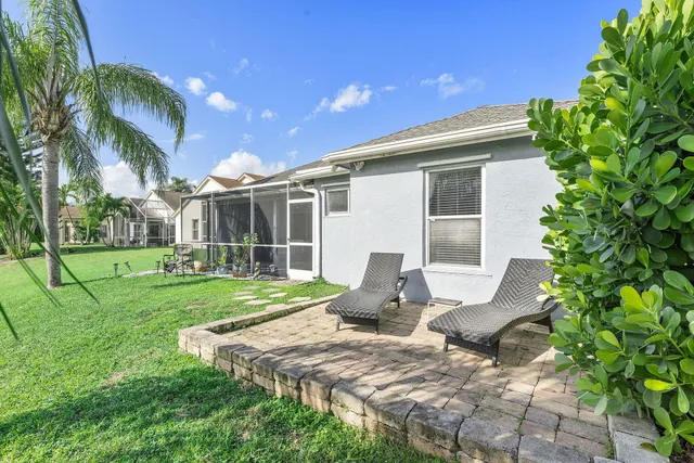 a view of a house with backyard and sitting area