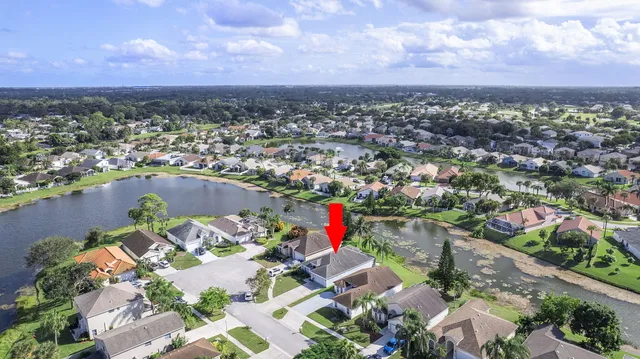 an aerial view of residential houses with outdoor space and lake view