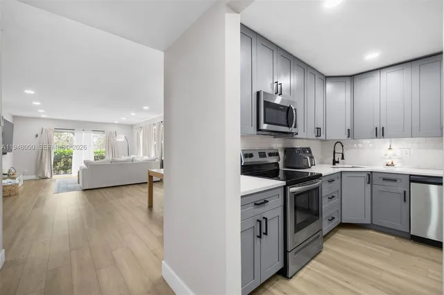 a kitchen with stainless steel appliances granite countertop wooden cabinets a stove top oven a sink and dishwasher