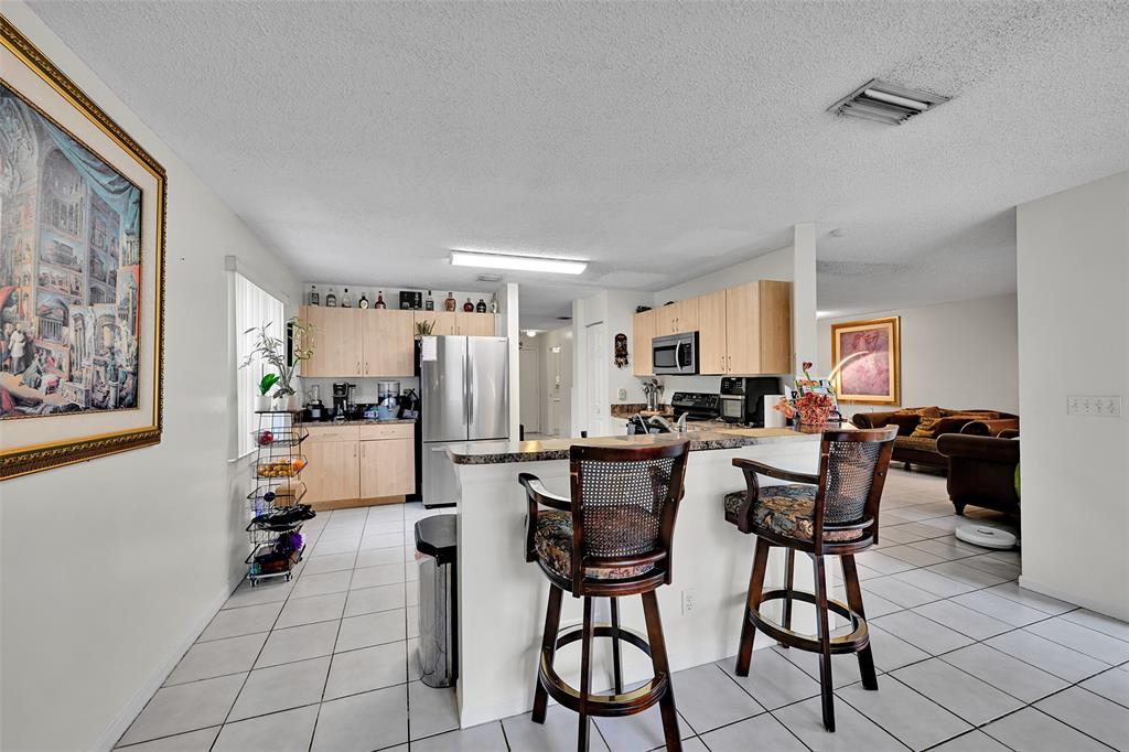 17332 Southwest 18th Street Miramar, FL 33029 - Photo 13 of 43 a living room with furniture and kitchen view