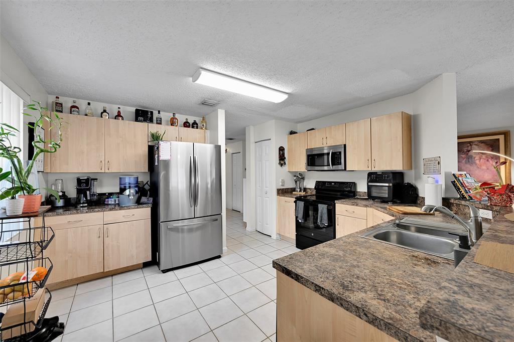 17332 Southwest 18th Street Miramar, FL 33029 - Photo 15 of 43 a kitchen with stainless steel appliances granite countertop a refrigerator stove microwave and sink