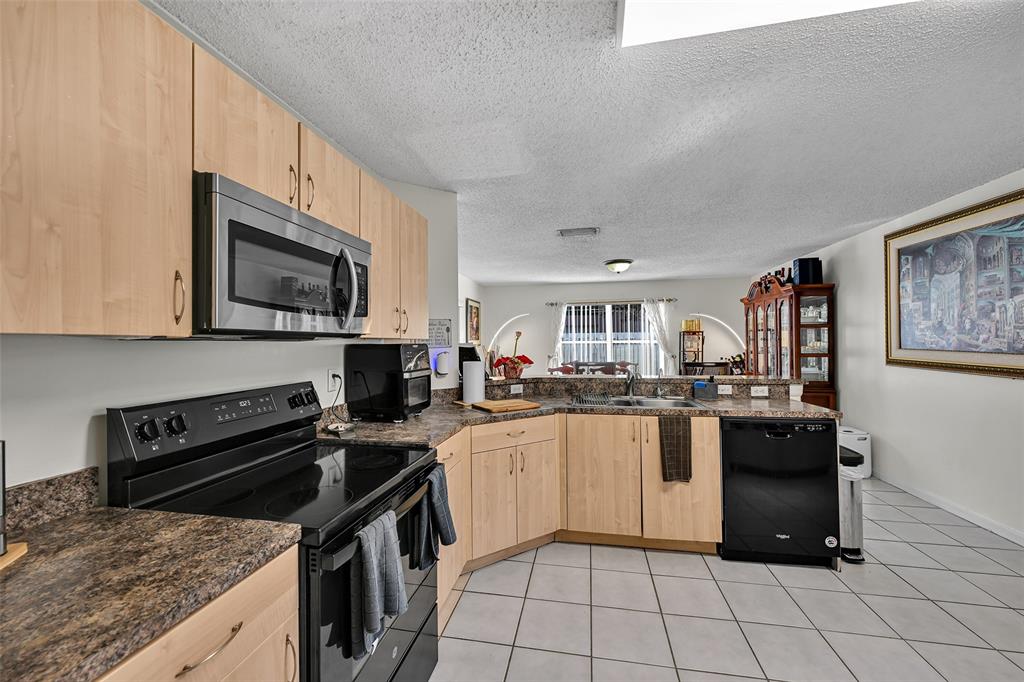 17332 Southwest 18th Street Miramar, FL 33029 - Photo 16 of 43 a kitchen with a sink stove and microwave