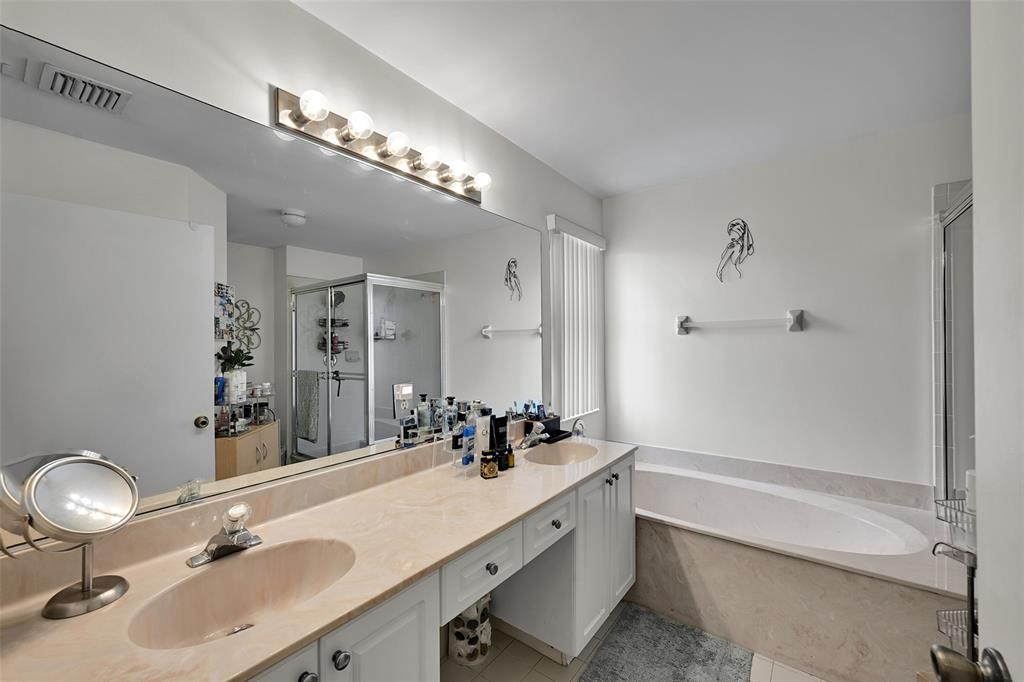 17332 Southwest 18th Street Miramar, FL 33029 - Photo 26 of 43 a bathroom with a sink double vanity granite tub and a mirror