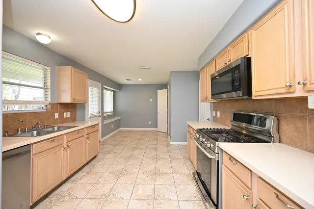 a view of a hallway with wooden floor and a chandelier