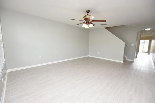 an empty room with a window and a fan