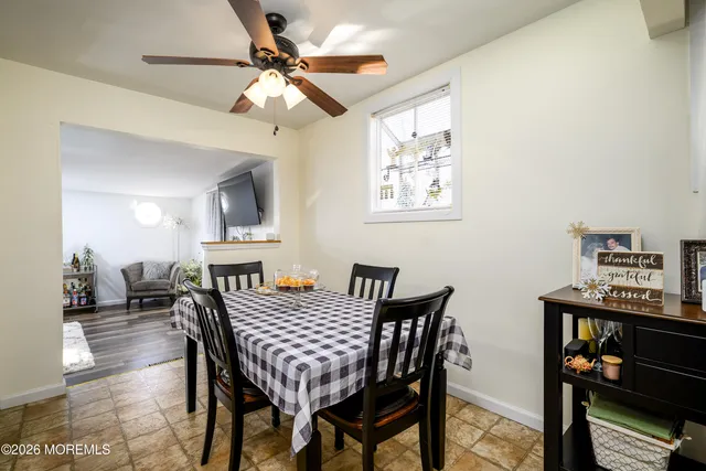 a kitchen with stainless steel appliances kitchen island granite countertop a refrigerator a stove a sink a dining table and chairs with wooden floor