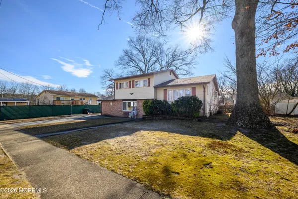 a view of a house with backyard and tree