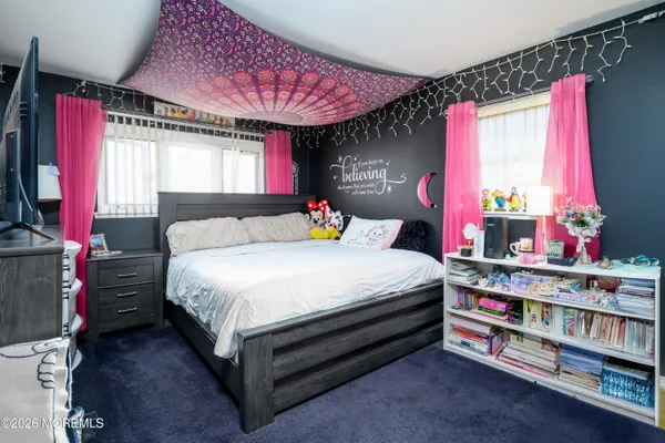 a bedroom with a bed a dresser and a window