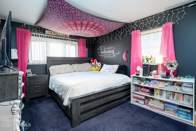 a bedroom with a bed a dresser and a window