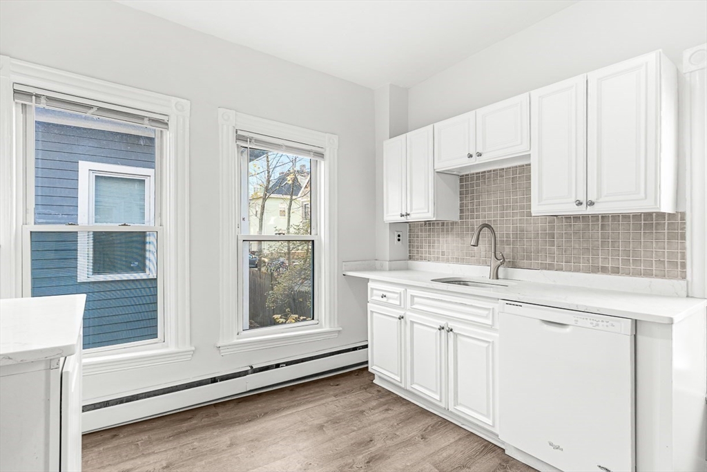 22 Royal Street Boston, MA 02134 - Photo 15 of 42 a kitchen with stainless steel appliances granite countertop a sink and cabinets with wooden floor