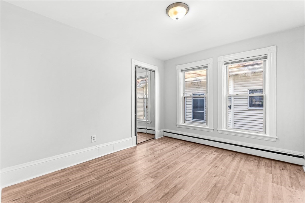 22 Royal Street Boston, MA 02134 - Photo 18 of 42 an empty room with wooden floor and windows