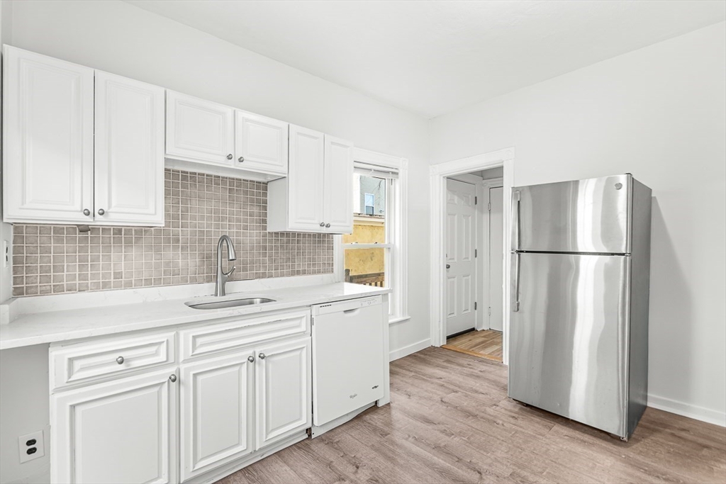 22 Royal Street Boston, MA 02134 - Photo 10 of 42 a kitchen with a refrigerator sink and cabinets