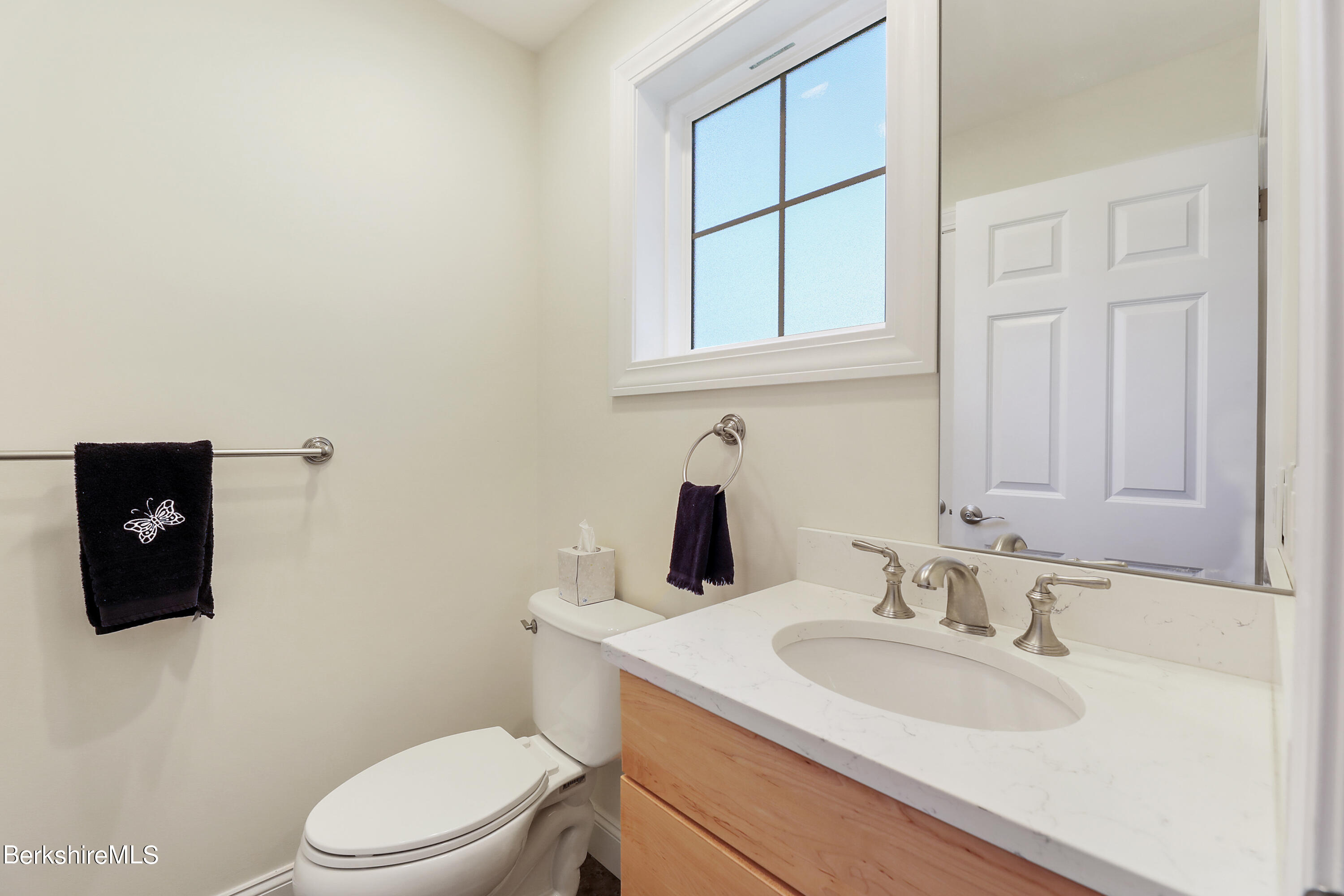 16 Spruce Trail, Unit 16 Lenox, MA 01240 - Photo 16 of 33 a bathroom with a toilet sink vanity and mirror