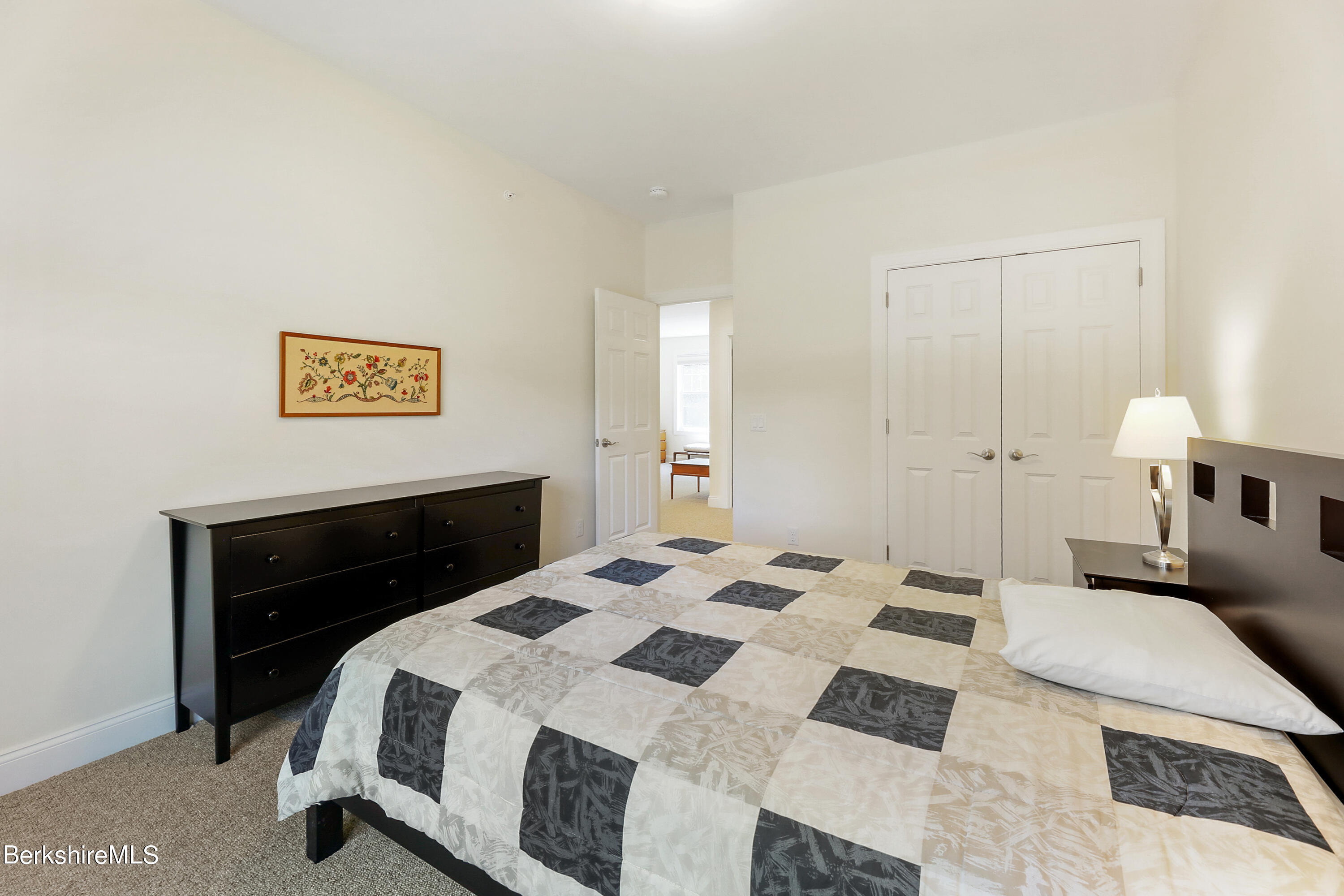 16 Spruce Trail, Unit 16 Lenox, MA 01240 - Photo 19 of 33 a bedroom with a bed and a lamp