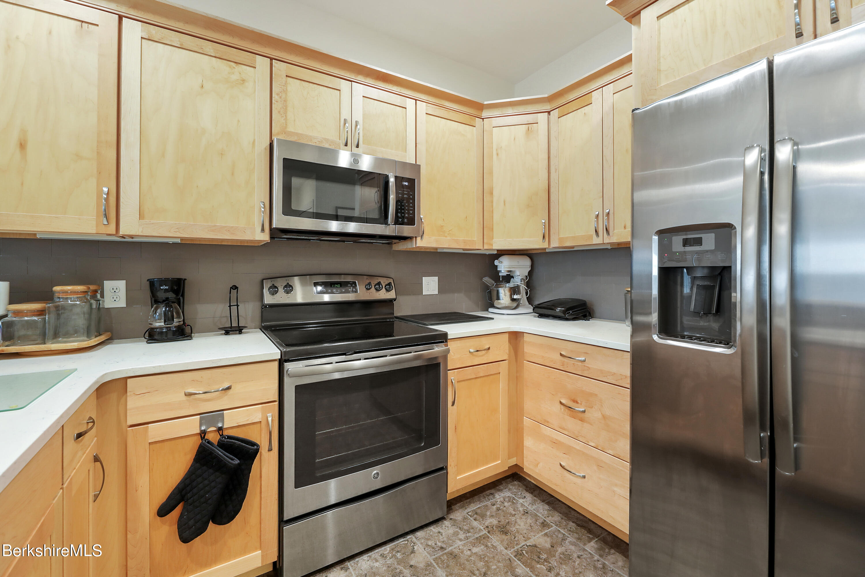 16 Spruce Trail, Unit 16 Lenox, MA 01240 - Photo 9 of 33 a kitchen with stainless steel appliances granite countertop a refrigerator a stove and white cabinets