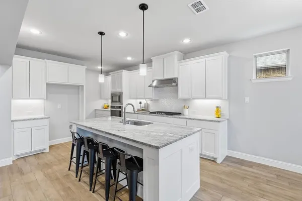 a kitchen with a table chairs refrigerator and microwave