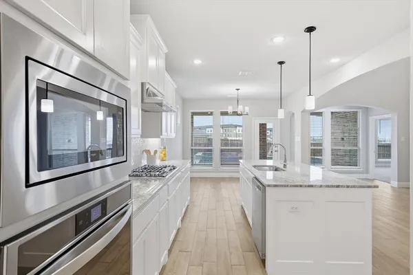a kitchen with stainless steel appliances a stove sink and cabinets