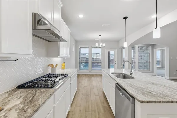 a large kitchen with kitchen island a large counter space a sink stainless steel appliances and cabinets