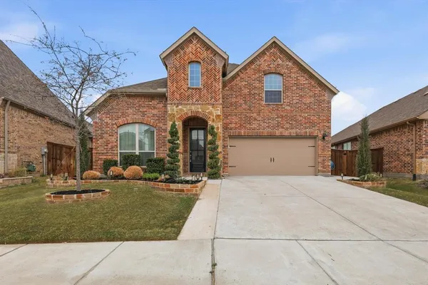 a front view of a house with yard and parking