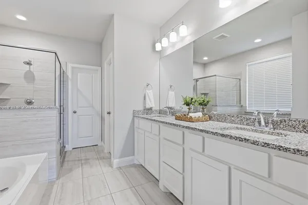 a bathroom with a double vanity sink mirror and shower