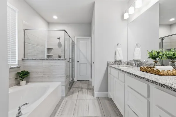 a bathroom with a granite countertop sink a mirror a bathtub and shower