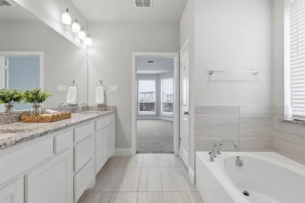 a bathroom with a tub sink and mirror