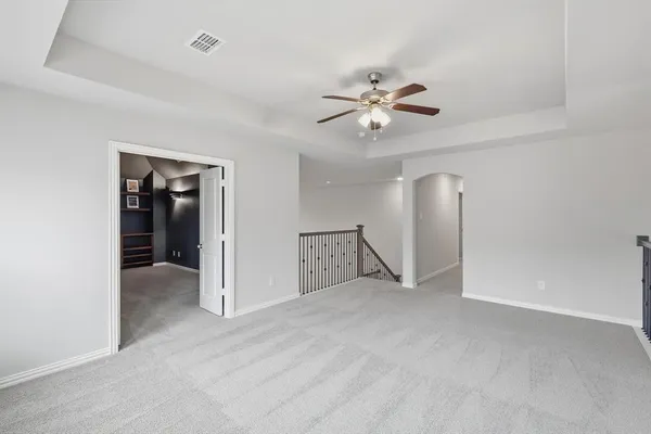 an empty room with closet and a ceiling fan