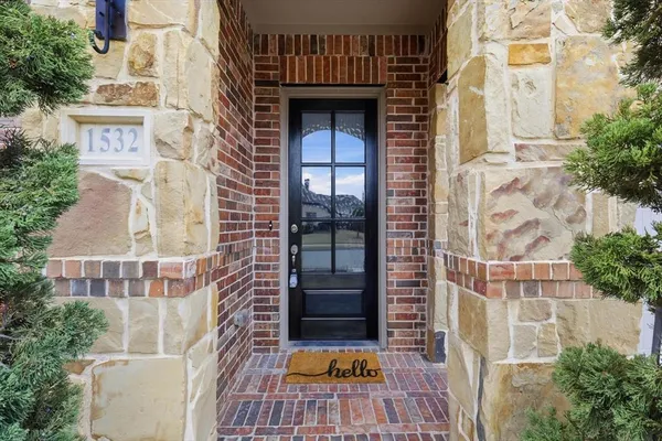 a view of a brick house with a large door and potted plants