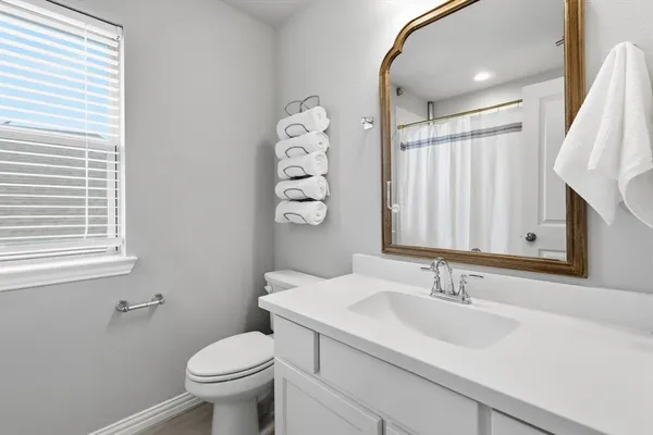 a bathroom with a sink toilet and a mirror