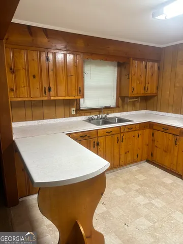 a kitchen with a sink a window and cabinets