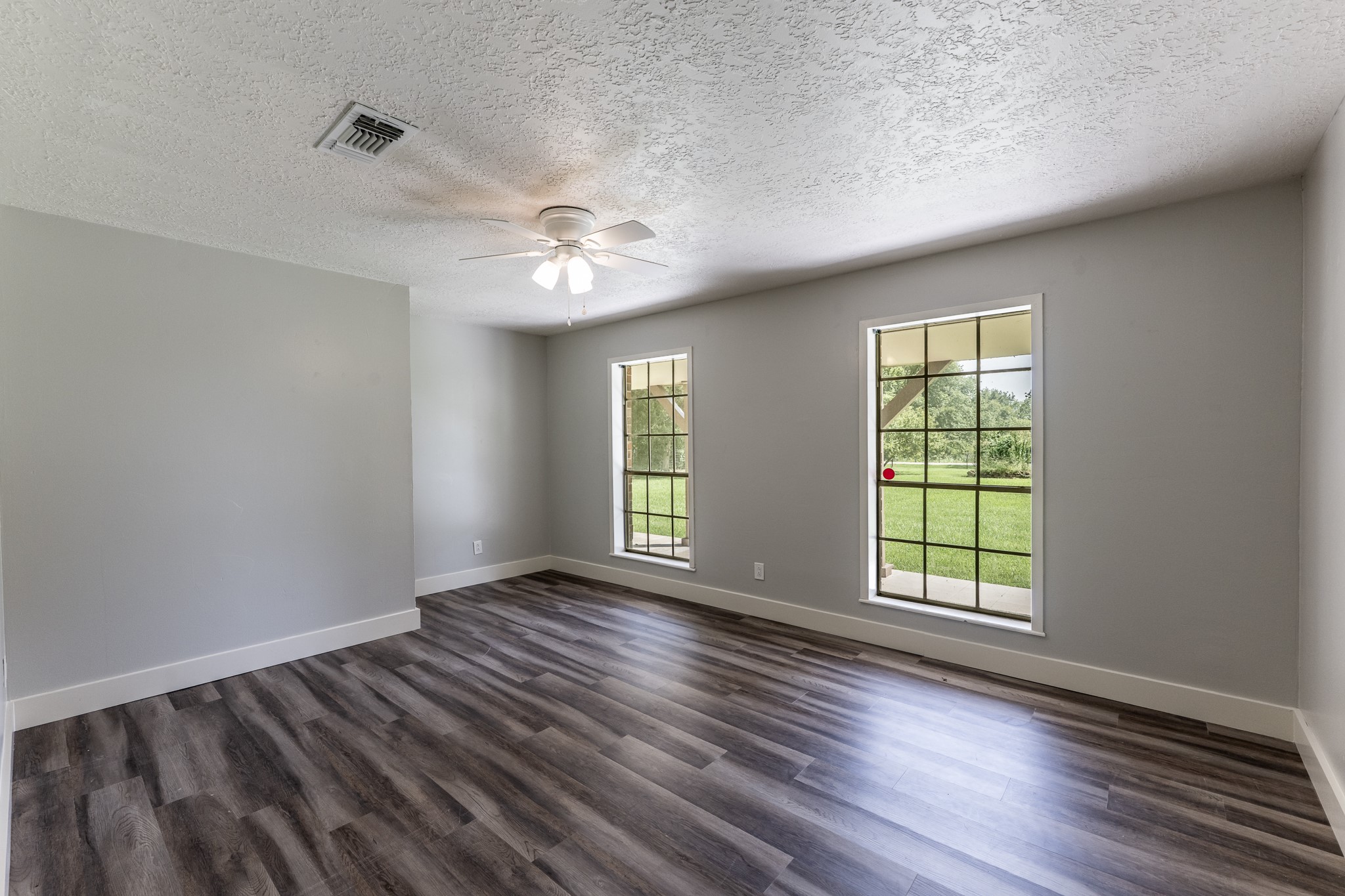 92 A Mt Zion Road New Waverly, TX 77358 - Photo 13 of 29 an empty room with wooden floor and windows