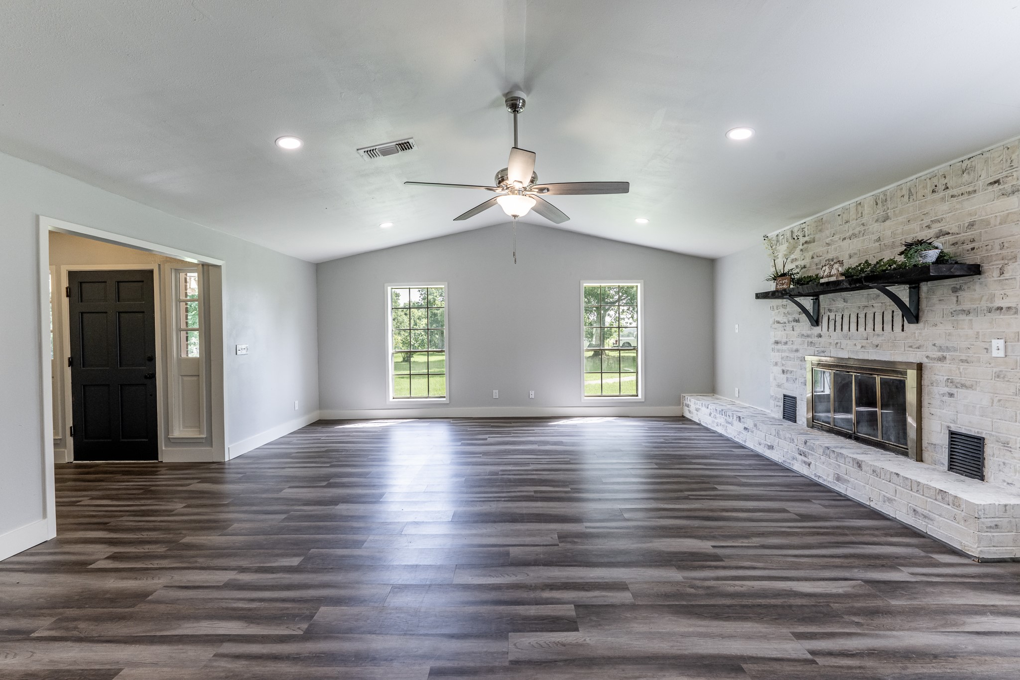 92 A Mt Zion Road New Waverly, TX 77358 - Photo 10 of 29 a view of an empty room with wooden floor fireplace and a window