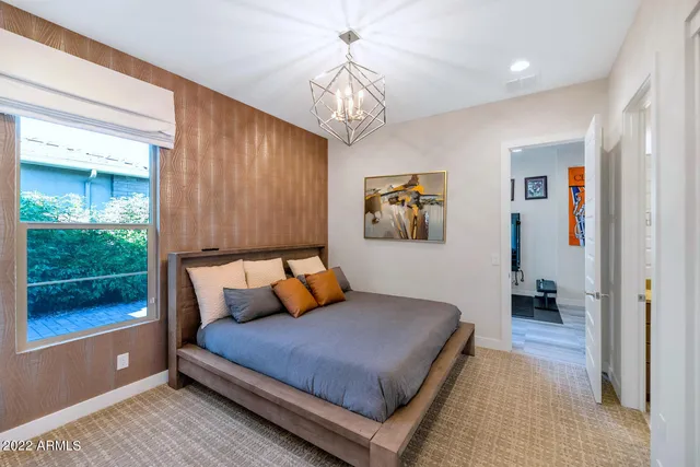a bedroom with a large bed and a chandelier