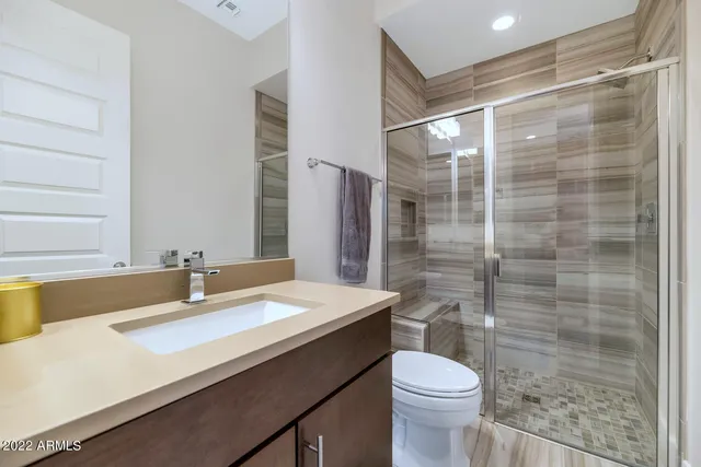 a bathroom with a sink a toilet and shower