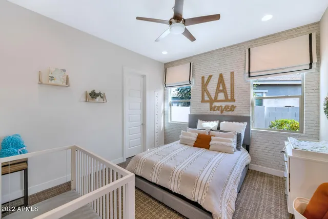 a bedroom with a bed a chandelier and dresser