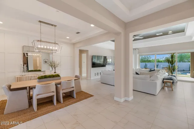 a living room with furniture a flat screen tv and a chandelier